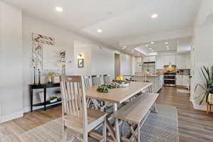 Dining room with light wood-type flooring and a raised ceiling