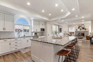 Kitchen with a kitchen island, white cabinetry, and sink