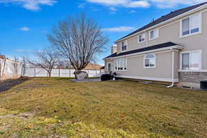 Rear view of property with a yard