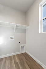 Laundry area with hardwood / wood-style flooring, washer hookup, and hookup for an electric dryer