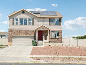 View of front facade with solar panels and a garage