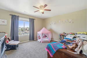 Carpeted bedroom with ceiling fan