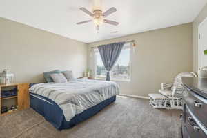 Carpeted bedroom with ceiling fan