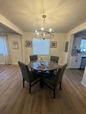 Dining area featuring  hardwood / wood-style floors, a textured ceiling, and a notable chandelier