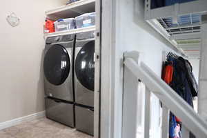 Laundry room featuring washing machine and dryer and light tile patterned floors