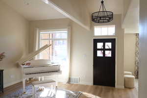 Foyer featuring light hardwood / wood-style flooring and a notable chandelier