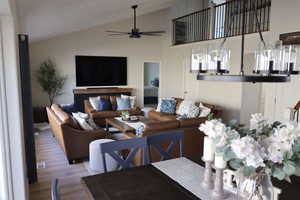 Living room featuring ceiling fan, light hardwood / wood-style floors, and lofted ceiling