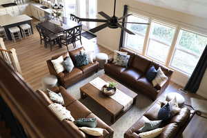 Living room with hardwood / wood-style floors, ceiling fan, lofted ceiling, and sink