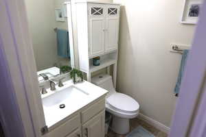 Bathroom featuring tile patterned floors, vanity, and toilet