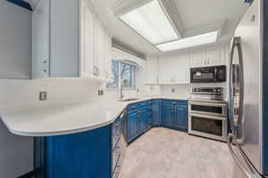 Kitchen with stainless steel appliances, two-toned cabinets, and quartz countertops