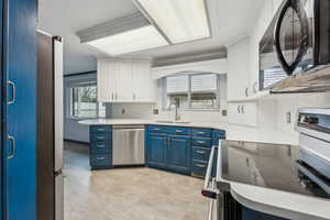 Kitchen with stainless steel appliances, two-toned cabinets, and quartz countertops