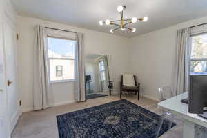 Carpeted office space with a chandelier