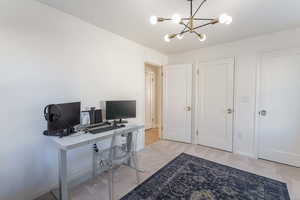 Carpeted office with a notable chandelier