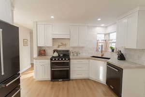 Kitchen featuring white cabinets, appliances with stainless steel finishes, and sink