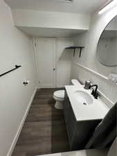 Bathroom with vanity, toilet, and wood-type flooring