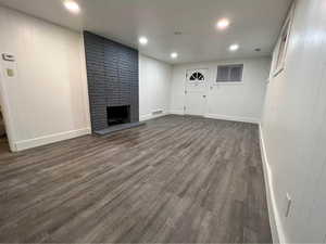 Unfurnished living room featuring a fireplace and dark hardwood / wood-style flooring