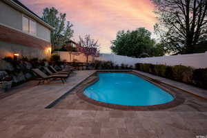 Pool at dusk featuring a sundeck