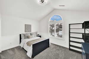 Bedroom featuring carpet floors and vaulted ceiling