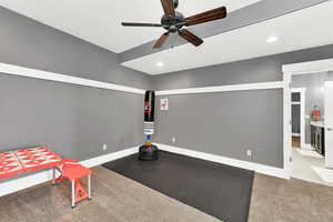 Bedroom with dark colored carpet and ceiling fan