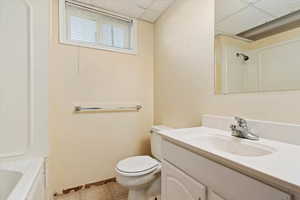 Bathroom with a drop ceiling, vanity, and toilet