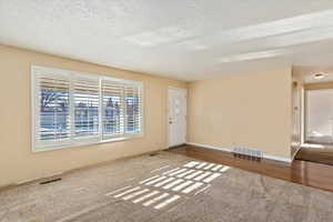 Carpeted empty room with a textured ceiling