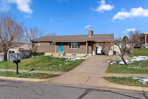 Single story home featuring a carport and a front yard