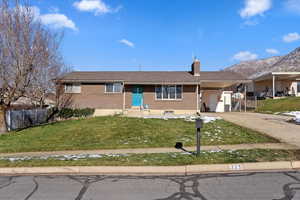 Ranch-style home with a front yard and a carport