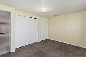 Unfurnished bedroom with a closet and a textured ceiling