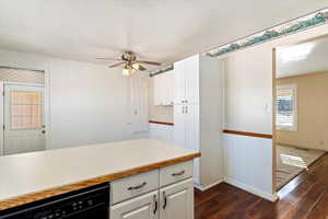 Kitchen with dishwasher, ceiling fan, white cabinetry, and dark wood-type flooring