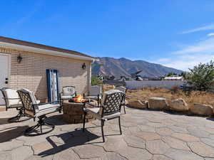 View of patio with a mountain view and a fire pit