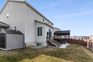 Rear view of property with a mountain view, a storage shed, a gazebo, a yard, and a patio