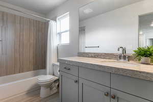 Full bathroom featuring vanity, shower / bath combo, and toilet