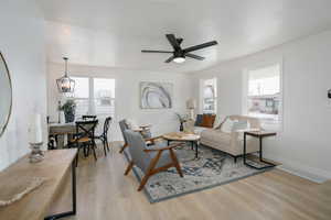 Living room featuring light hardwood / wood-style floors and ceiling fan with notable chandelier