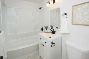 Full bathroom featuring vanity, shower / bath combination, and toilet