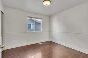 Empty room with dark wood-type flooring