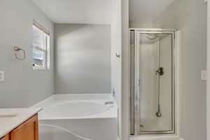 Bathroom featuring vanity and shower with separate bathtub