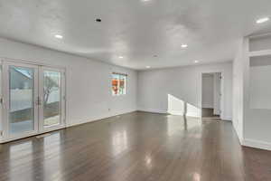 Empty room featuring french doors and dark hardwood / wood-style flooring