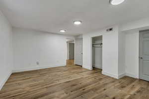 Unfurnished bedroom featuring a closet and light wood-type flooring