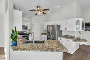 Kitchen featuring white cabinets, sink, kitchen peninsula, and stainless steel appliances