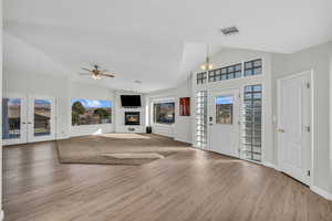 Foyer with ceiling fan, light hardwood / wood-style floors, lofted ceiling, and french doors