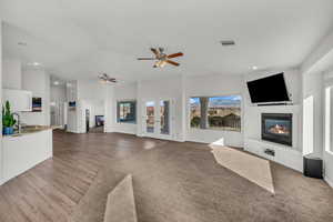 Unfurnished living room featuring ceiling fan, french doors, sink, vaulted ceiling, and hardwood / wood-style flooring