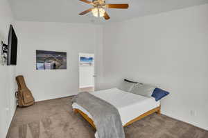 Carpeted bedroom featuring ceiling fan