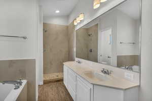 Full bathroom featuring hardwood / wood-style flooring, vanity, toilet, and plus walk in shower