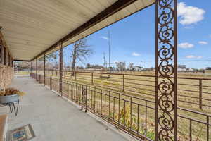 View of patio with covered porch and a rural view