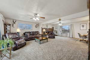 Living room featuring carpet flooring and ceiling fan