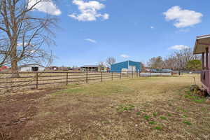 View of yard with a rural view and an outdoor structure