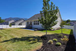 Rear view of house with a mountain view and a yard