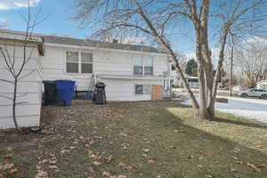 Rear view of property with a lawn