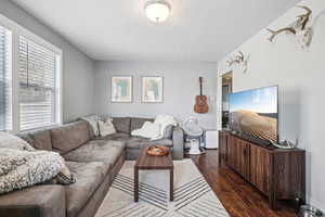 Living room with dark hardwood / wood-style flooring