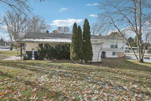 Rear view of house featuring a yard